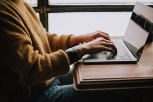 A woman sits at a laptop searching for cleaning companies that work for her business