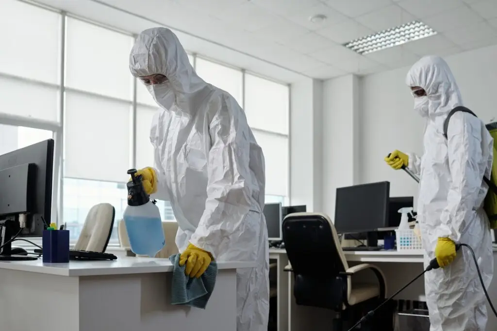 A two-man disinfecting team works in a commercial space