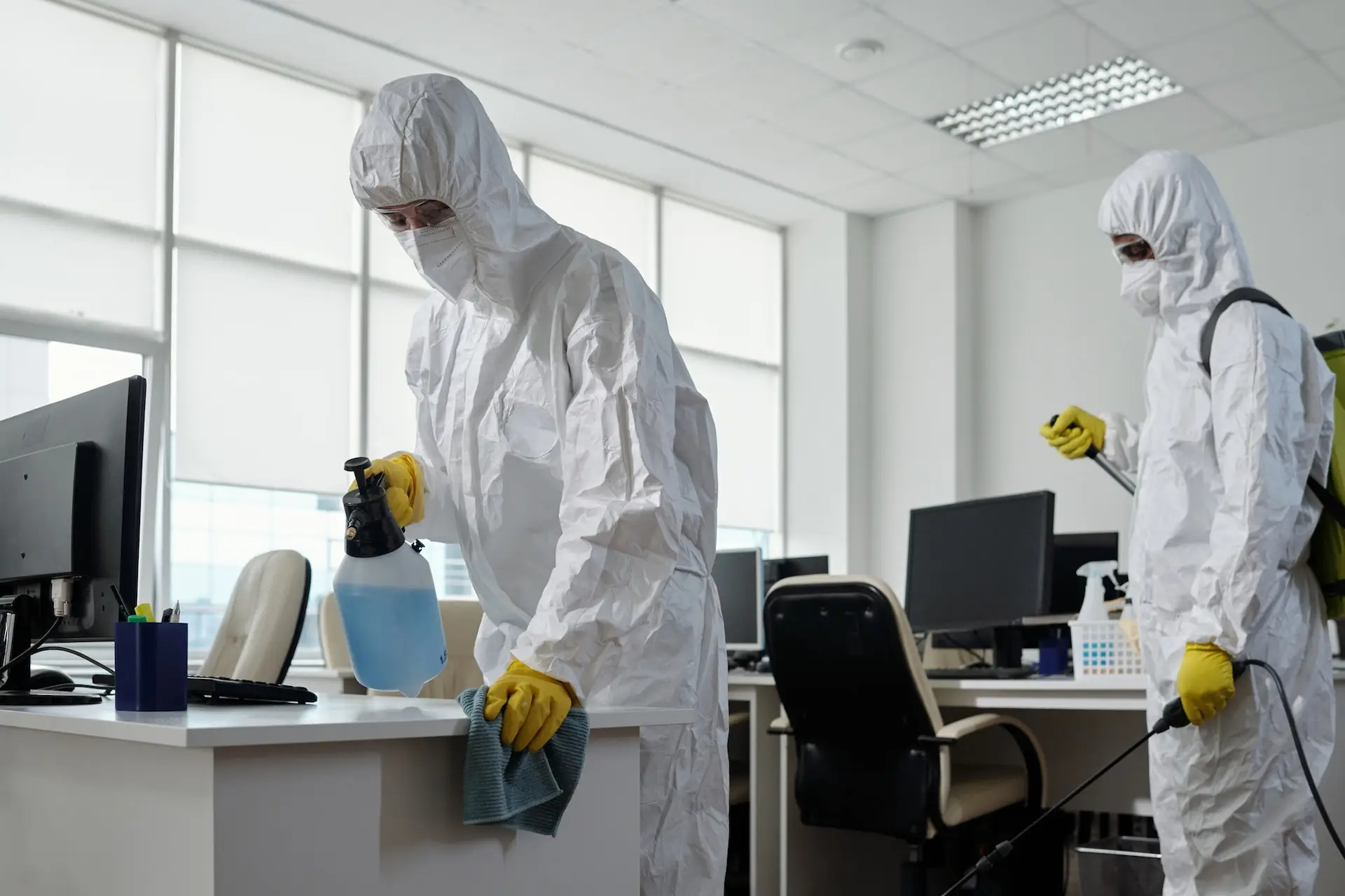 A two-man disinfecting team works in a commercial space