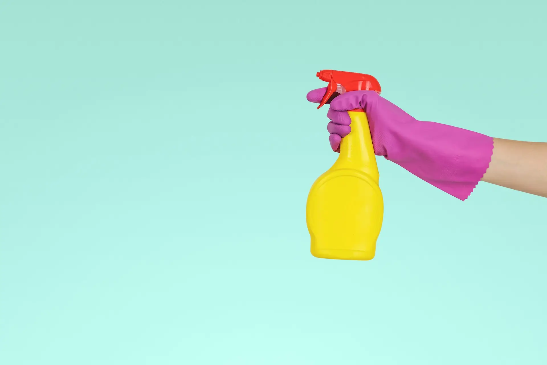 An aesthetic graphic of a gloved hand holding a yellow cleaning spray bottle