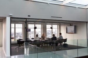 A glass walled meeting room in a business set up for success